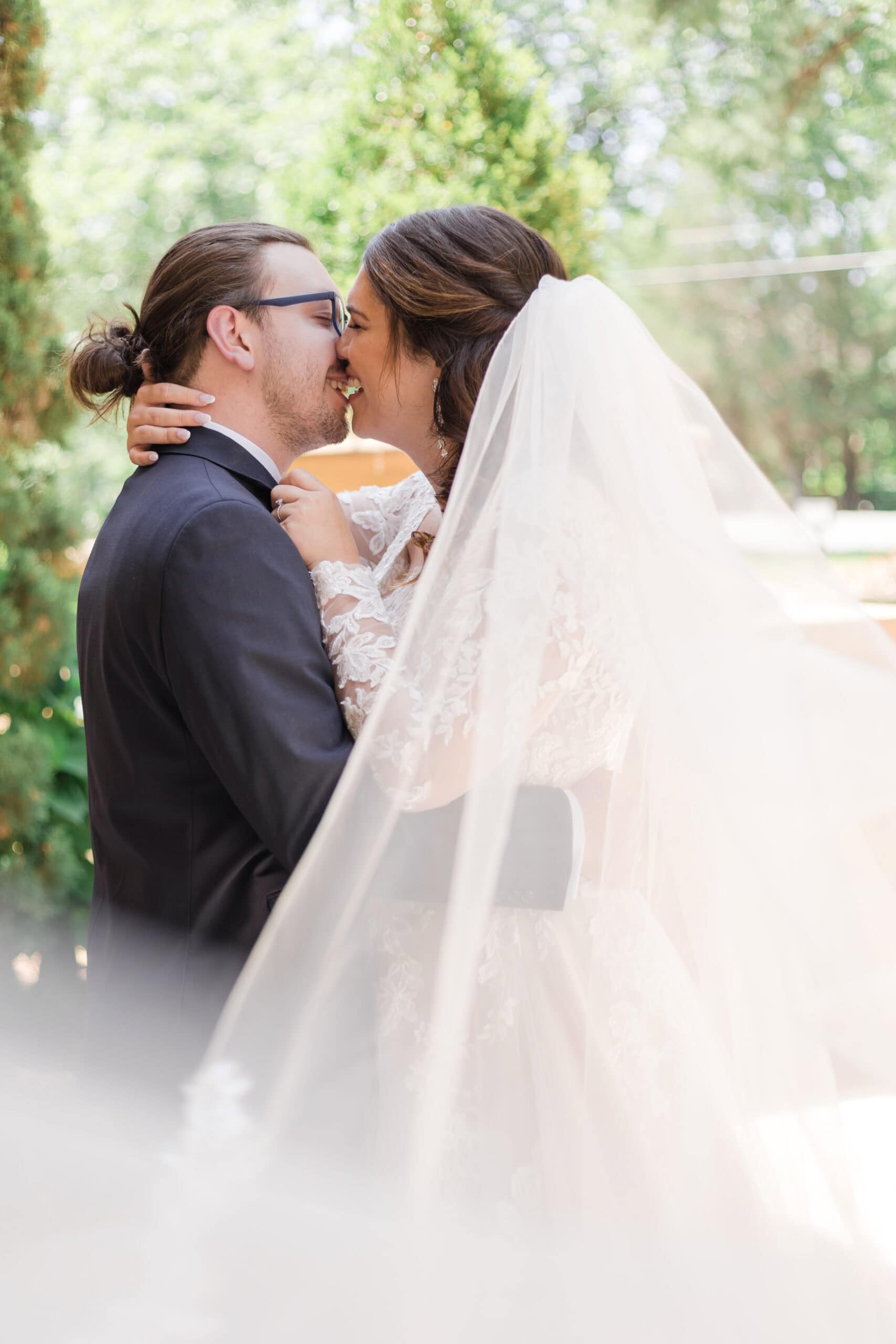 Bride with veil and groom embracing during wedding portraits | Wedding Photography