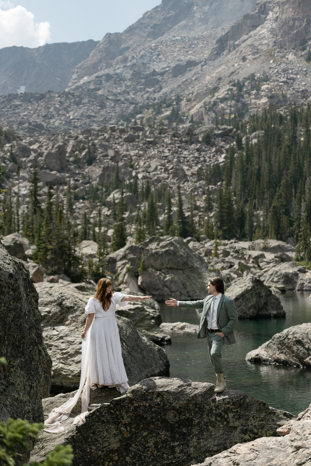 Intimate elopement moment, couple reaching out and hands almost touching, at Rocky Mountain National Park captured by a