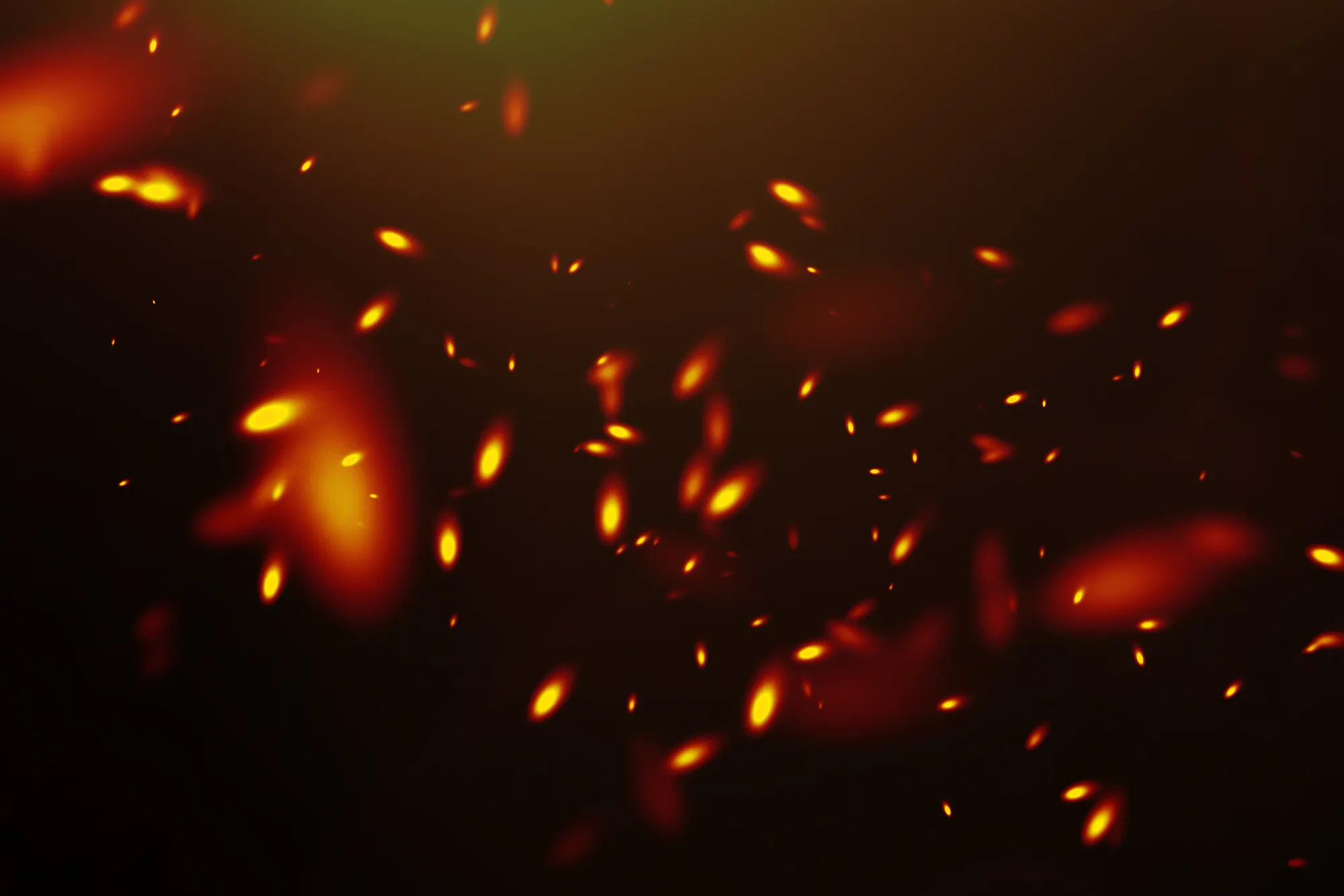 Abstract warm fire particles floating against a dark backdrop, creating a dynamic and atmospheric effect. Suitable for b