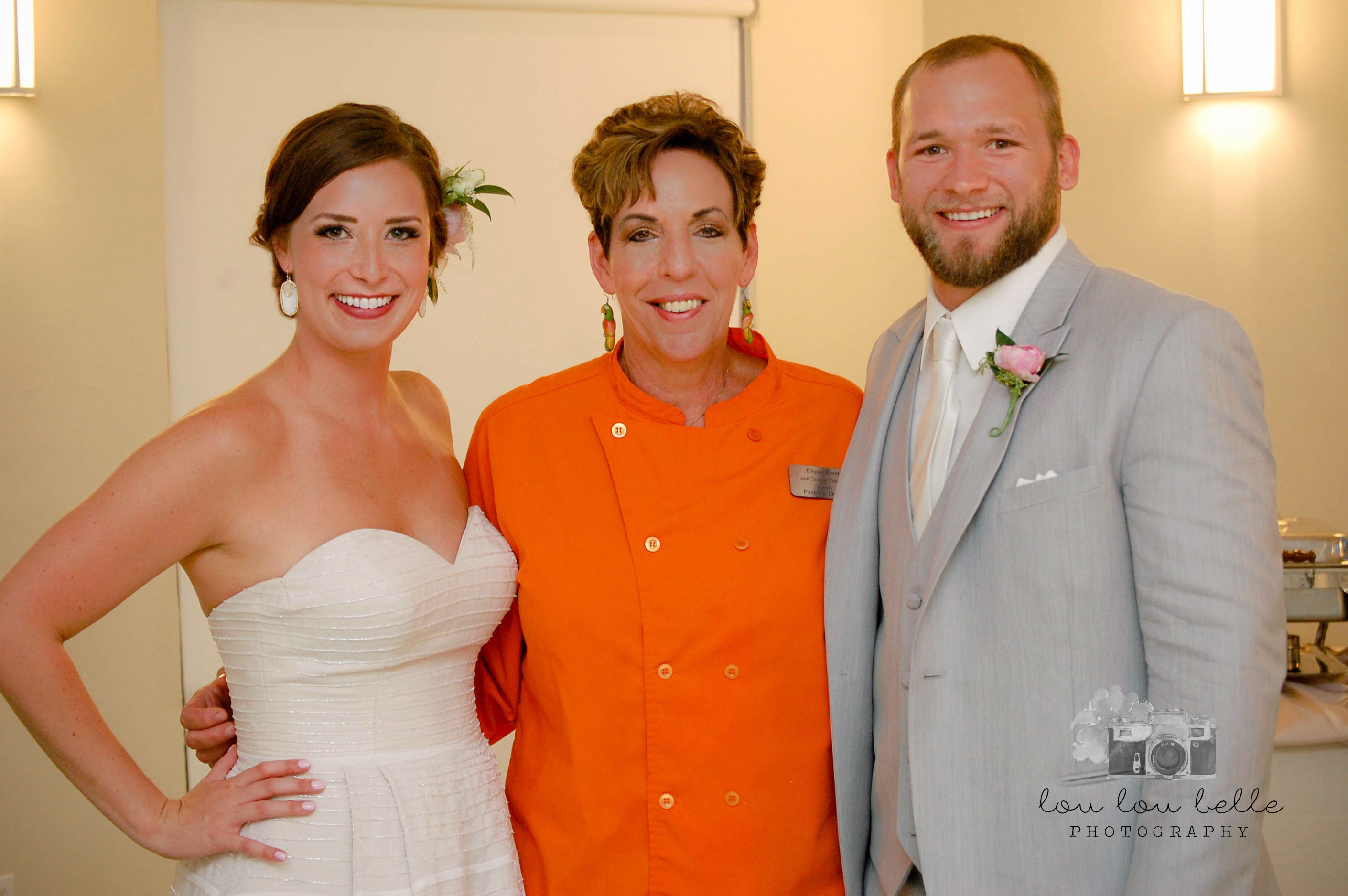 Chef posing with a bride and groom