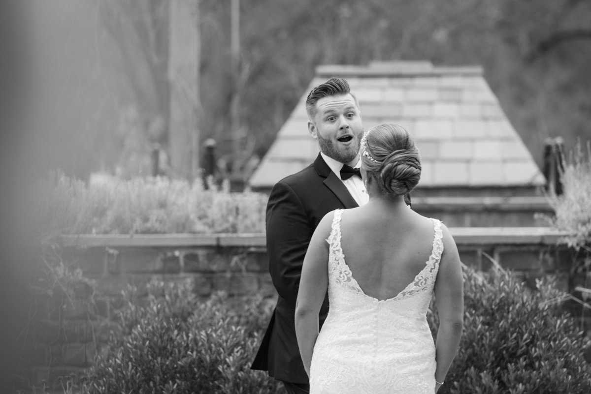 Groom reacting with surprise and emotion during the couple's first look before their wedding ceremony.