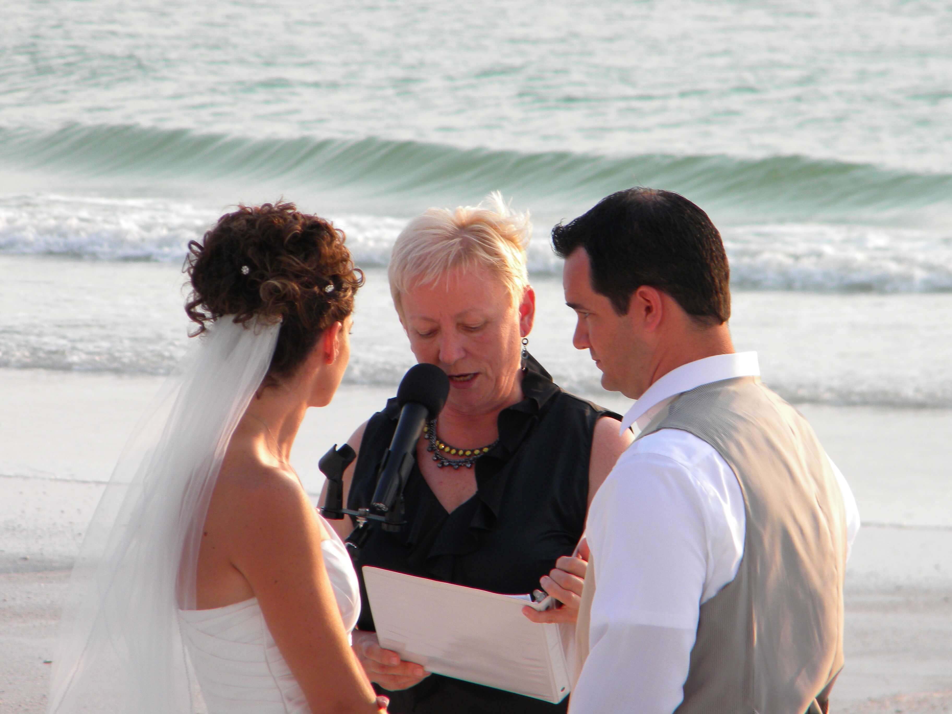 Eileen officiating the wedding and the groom looking at the bride