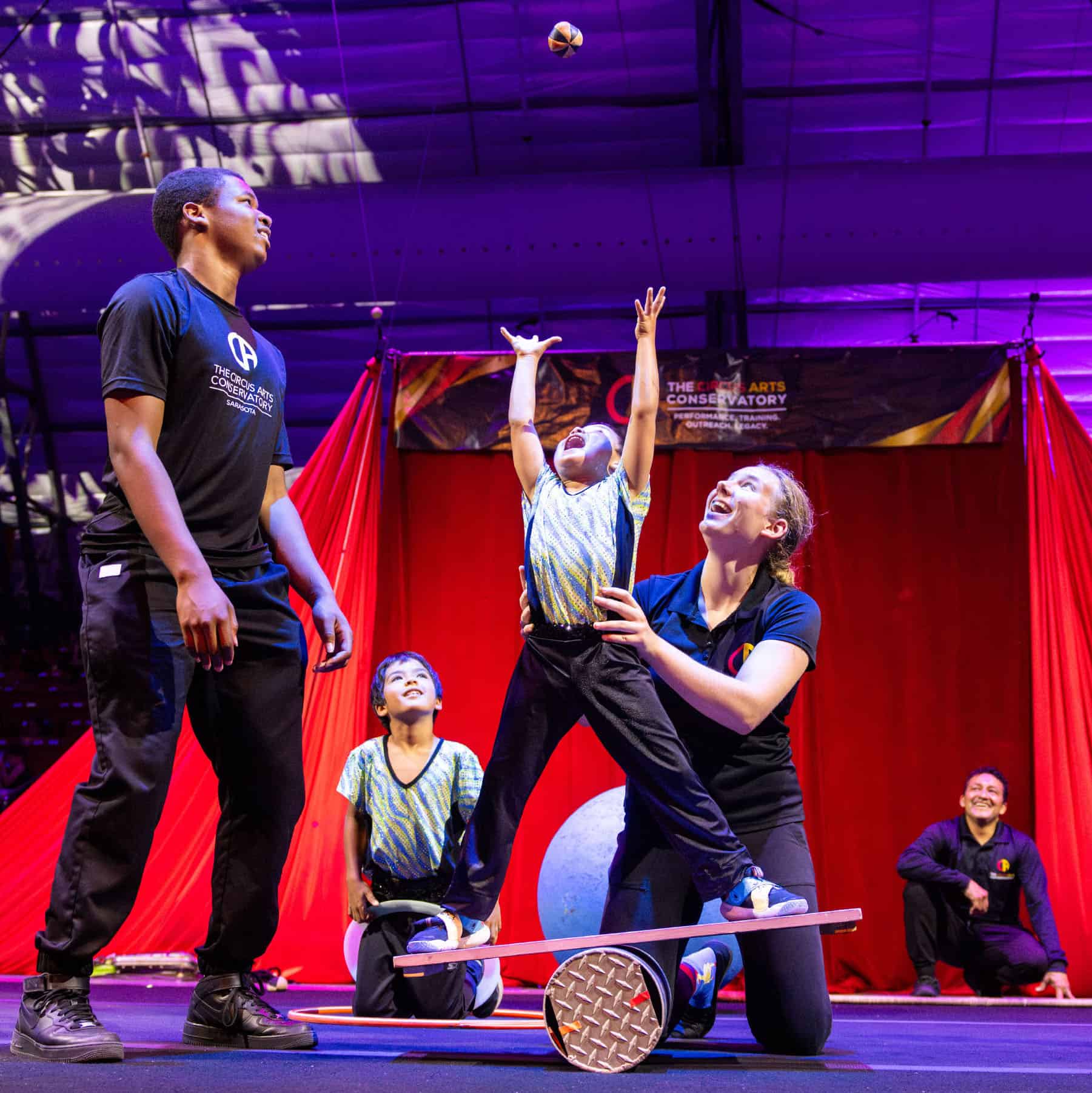 Kids circus stage performance with professional instructors and colorful lighting.