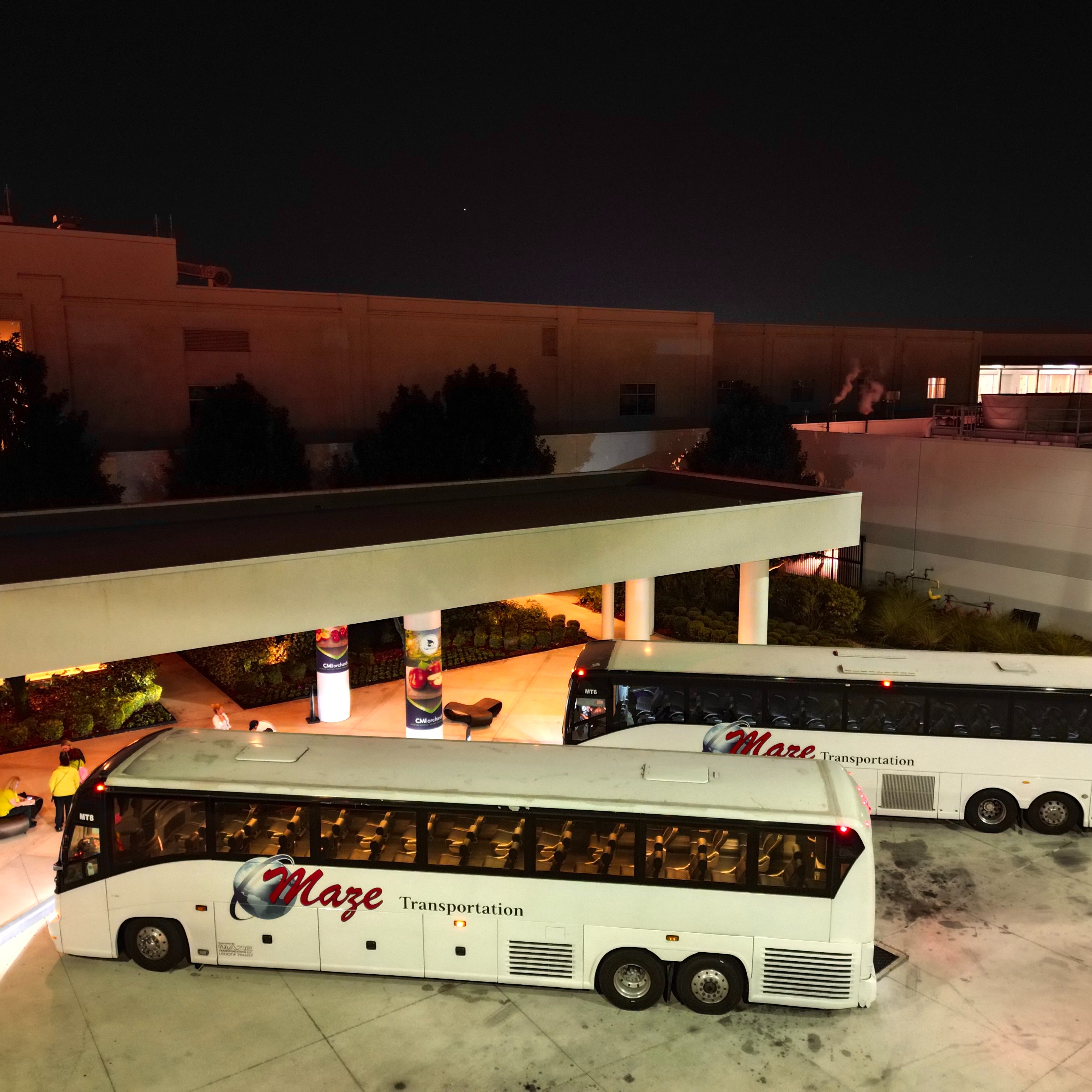 Charter bus at covered facility entrance at night