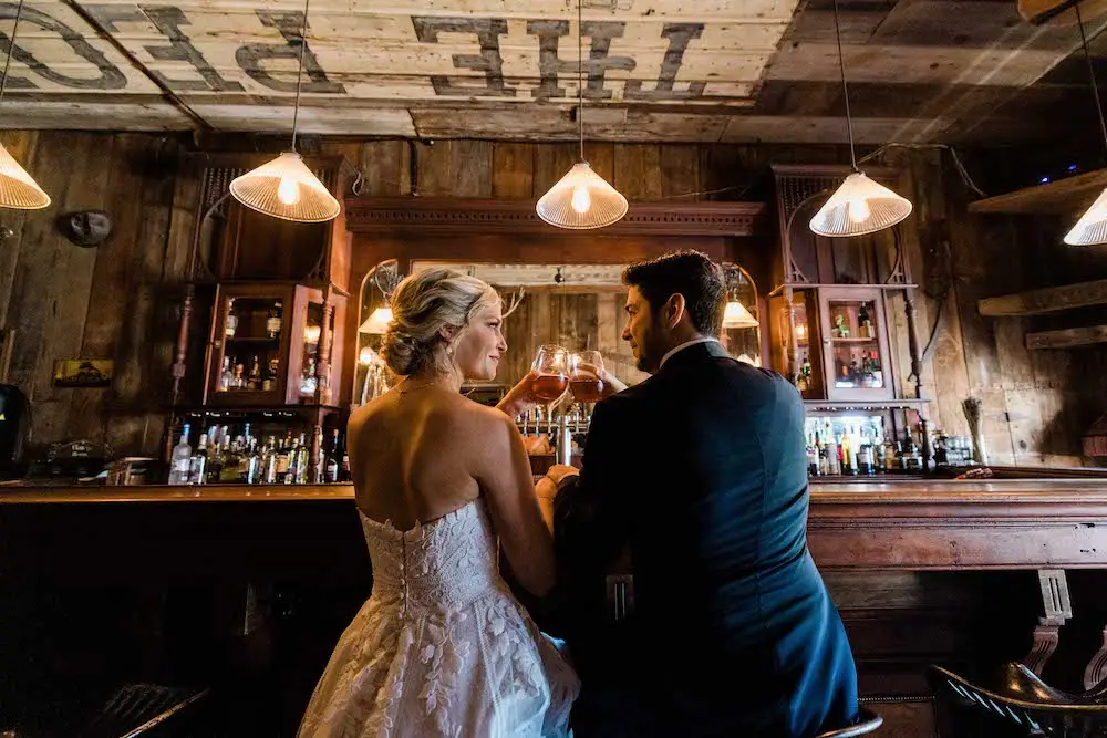 Bride and groom toasting at rustic bar