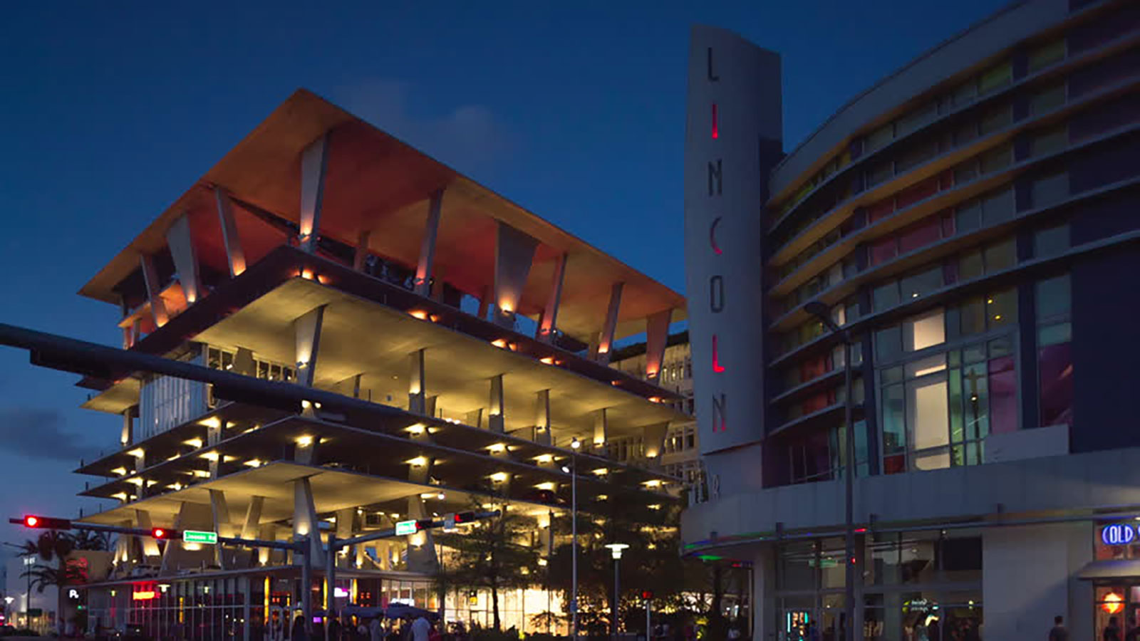 Illuminated Lincoln Road parking structure and vertical Lincoln sign at dusk, a Miami event venue near nightlife and sho
