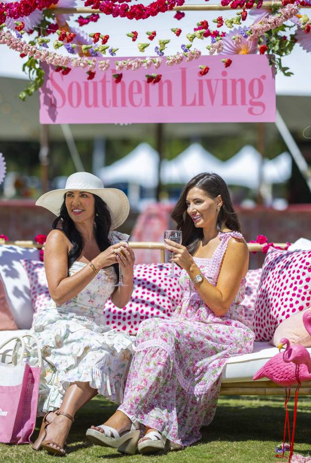 Two people seated on a decorated outdoor swing at a Southern Living event in Panama City Beach, Florida, featuring patte