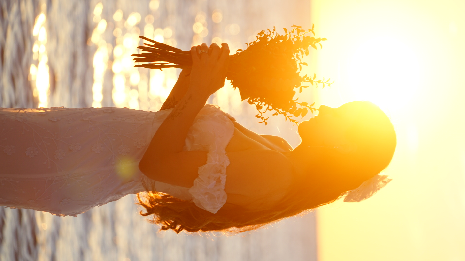 Romantic bride silhouette at sunset holding bouquet on the beach in Panama City Beach