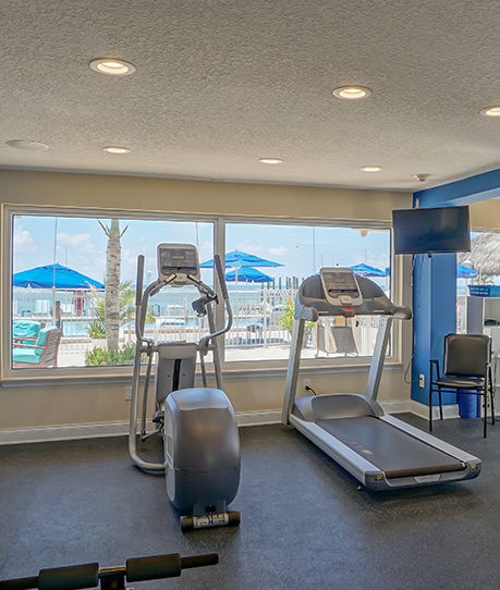 Modern fitness room with cardio machines and free weights at Glunz Resort
