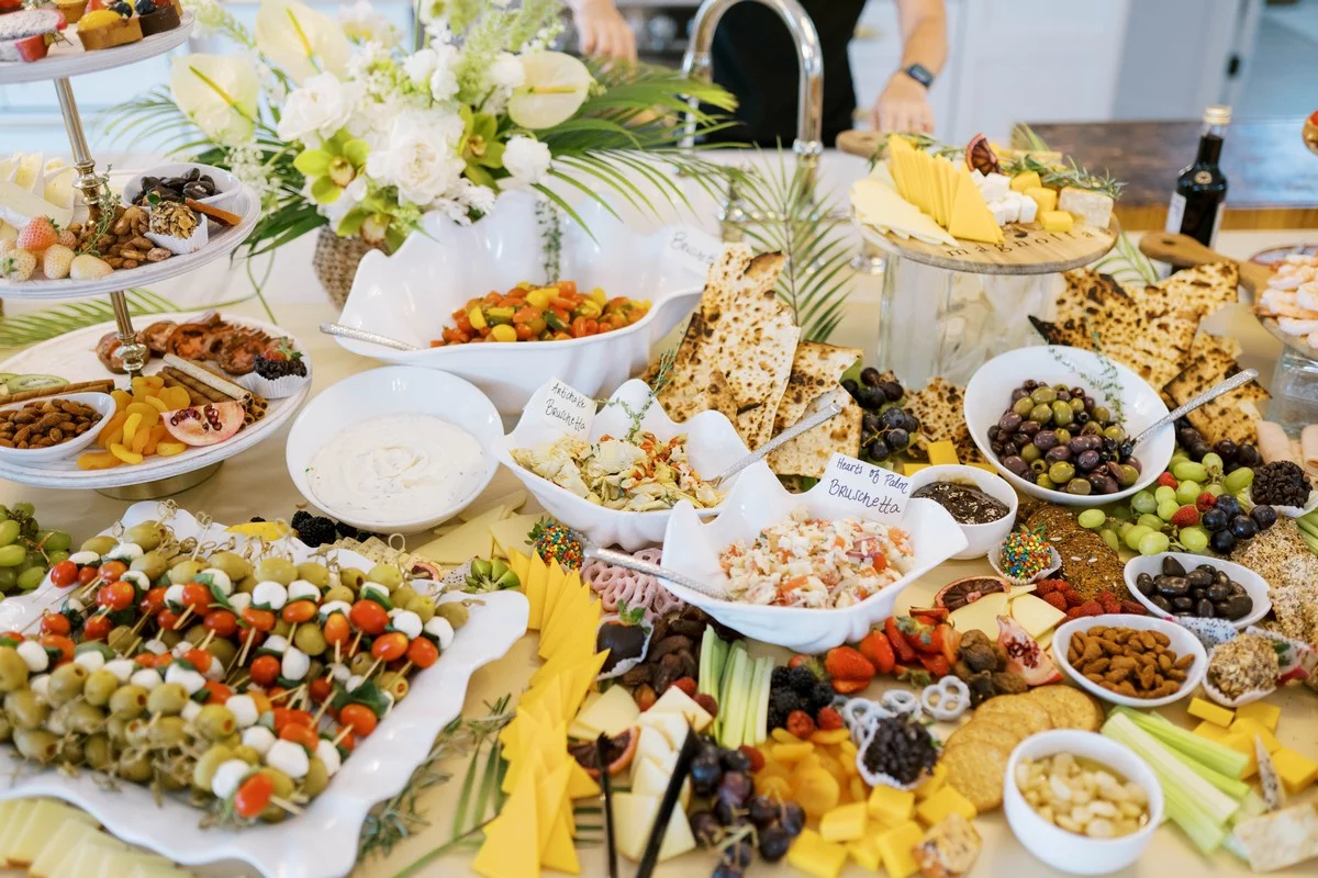 table spread with appetizers, olives, nuts, fruits, and cheeses