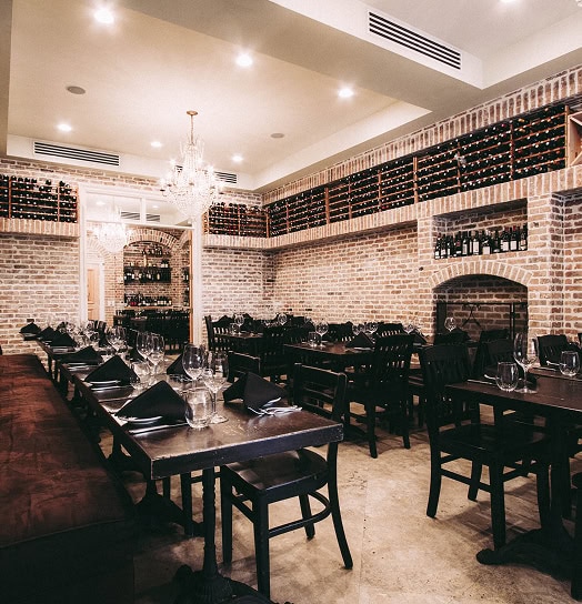 Cozy brick-walled restaurant interior with elegant dining setup at Olio.