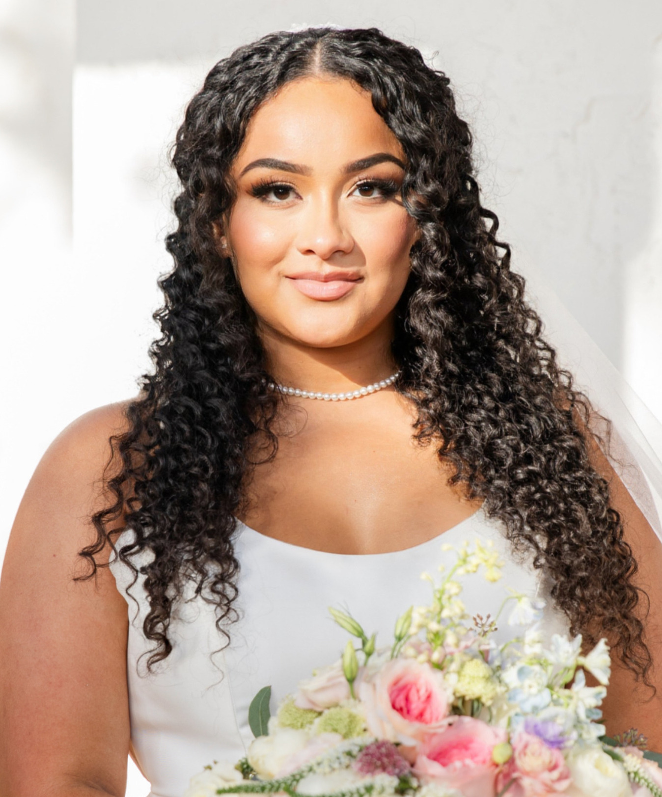 Naturally curly bridal hairstyle with defined soft curls and voluminous texture