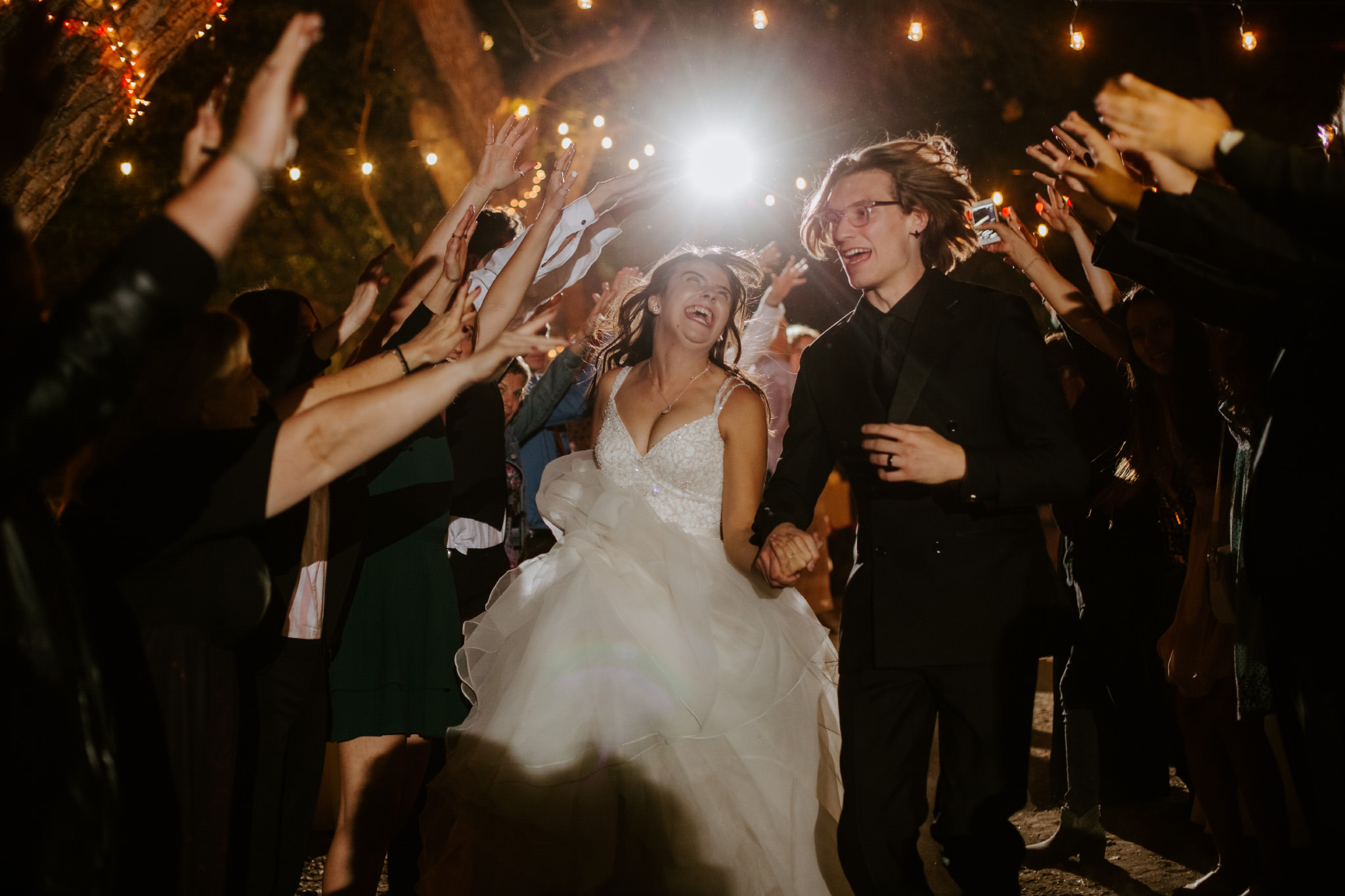 groom and bride with a grand reception exit with cell phone lights